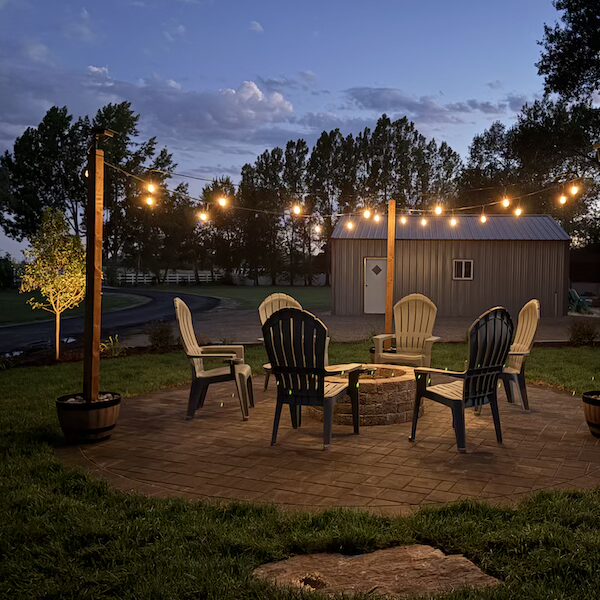 Paver and fire pit installation project, with outdoor lightning at night, in Rexburg